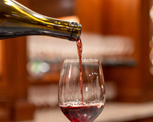 Red wine being poured into a glass during a complimentary tasting at CordeValle Winery